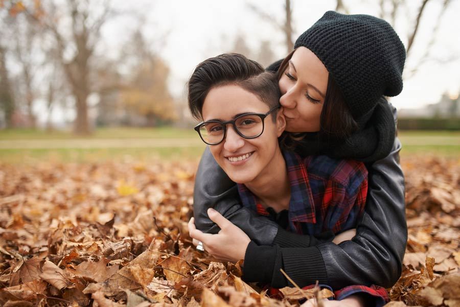 Photo of lesbian couple in autumn leaves